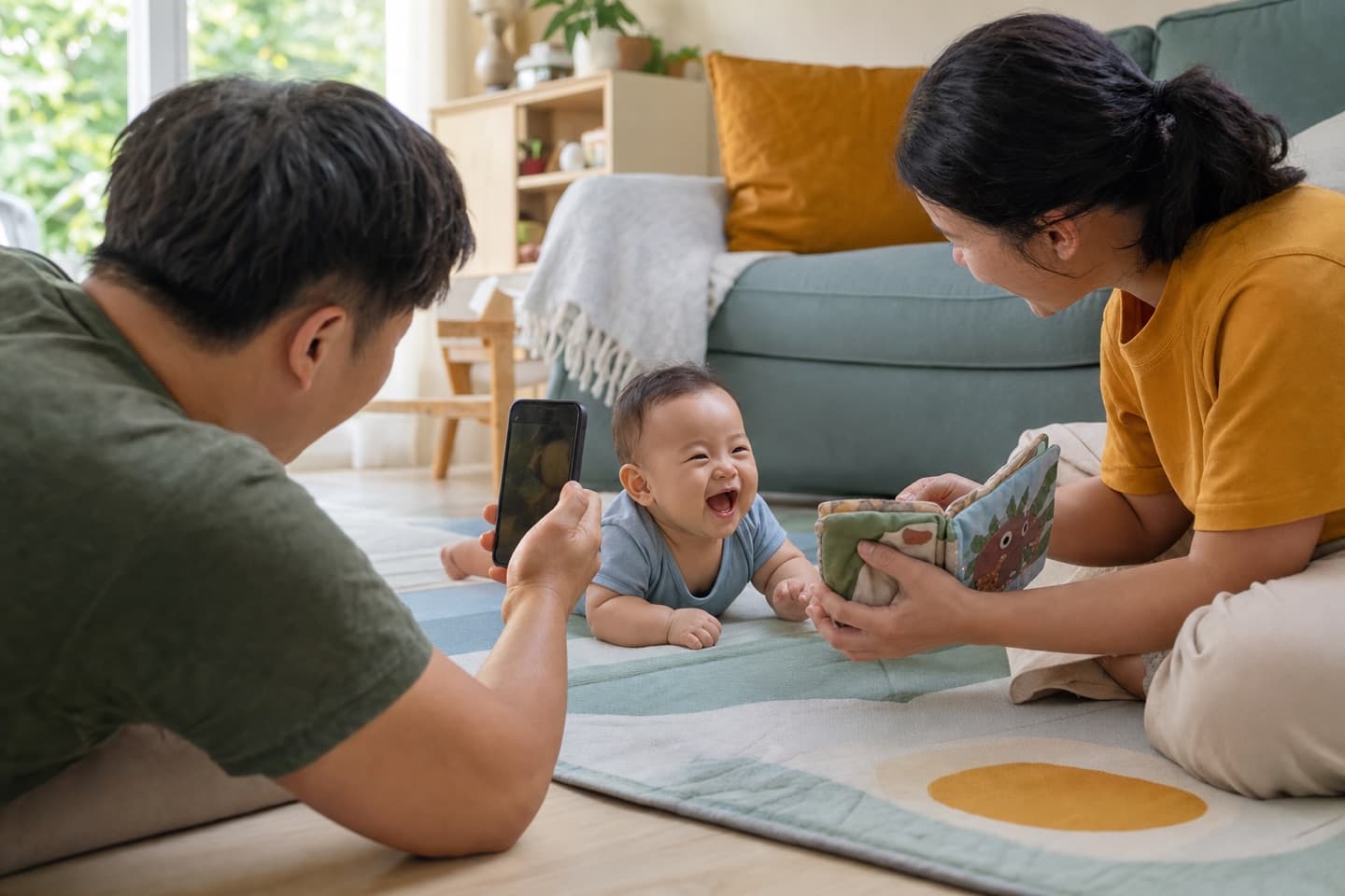 A baby laughing during floor play while parents save the movement and sound on video
